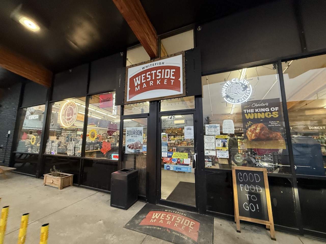The Westside Market storefront on 2nd Street in Whitefish at dusk